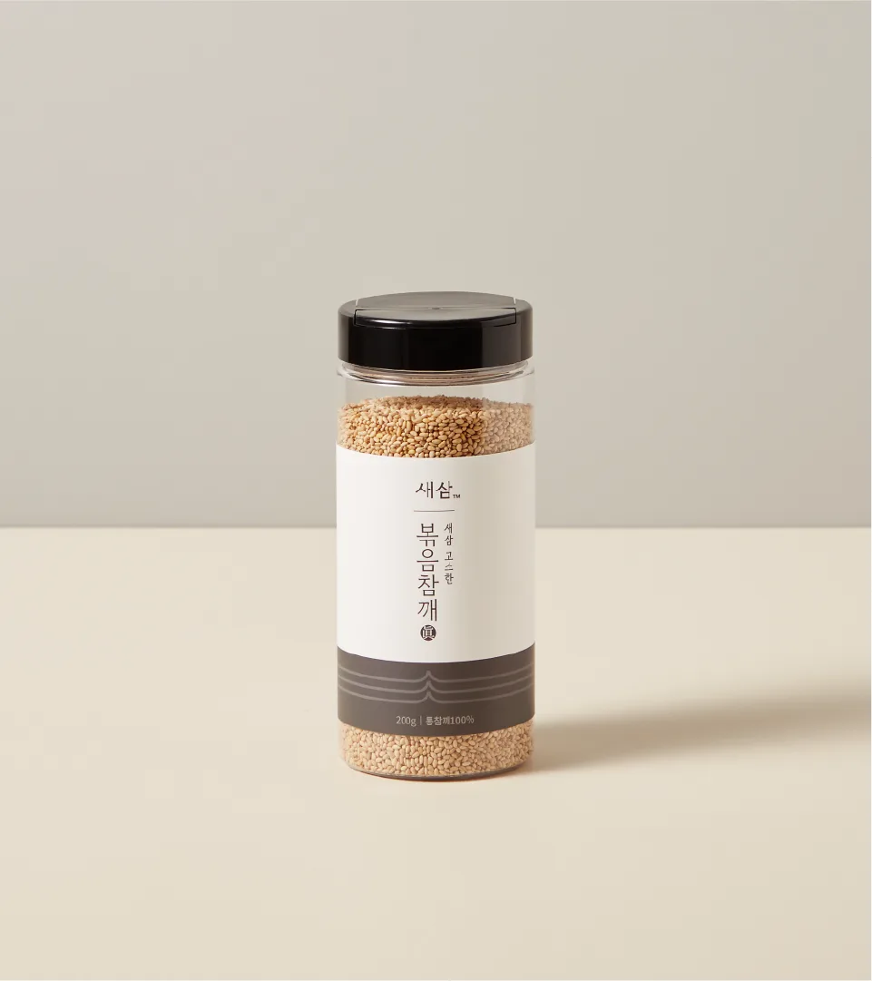 Roasted sesame seeds product from SESAM Oil House, showcasing a neat and minimalist package. Product shot of a transparent container with SESAM Oil House roasted sesame seed