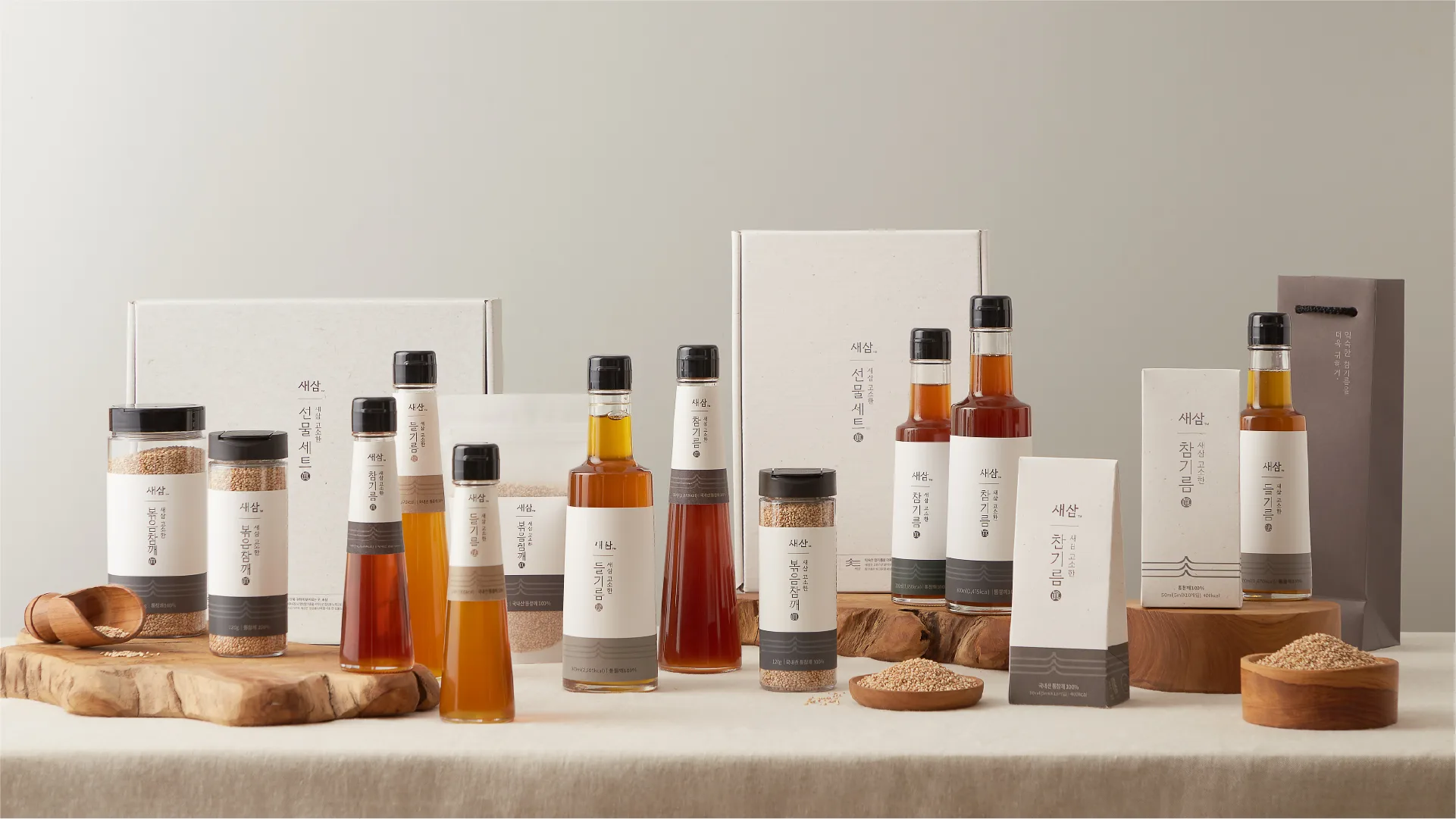 A comprehensive view of SESAM Oil House's premium products, crafted with 25 years of expertise. Sesame oil, perilla oil, and roasted sesame seeds in elegant, minimalist packaging, harmonizing with nat SESAM Oil House's premium sesame oil, perilla oil, and roasted sesame products.