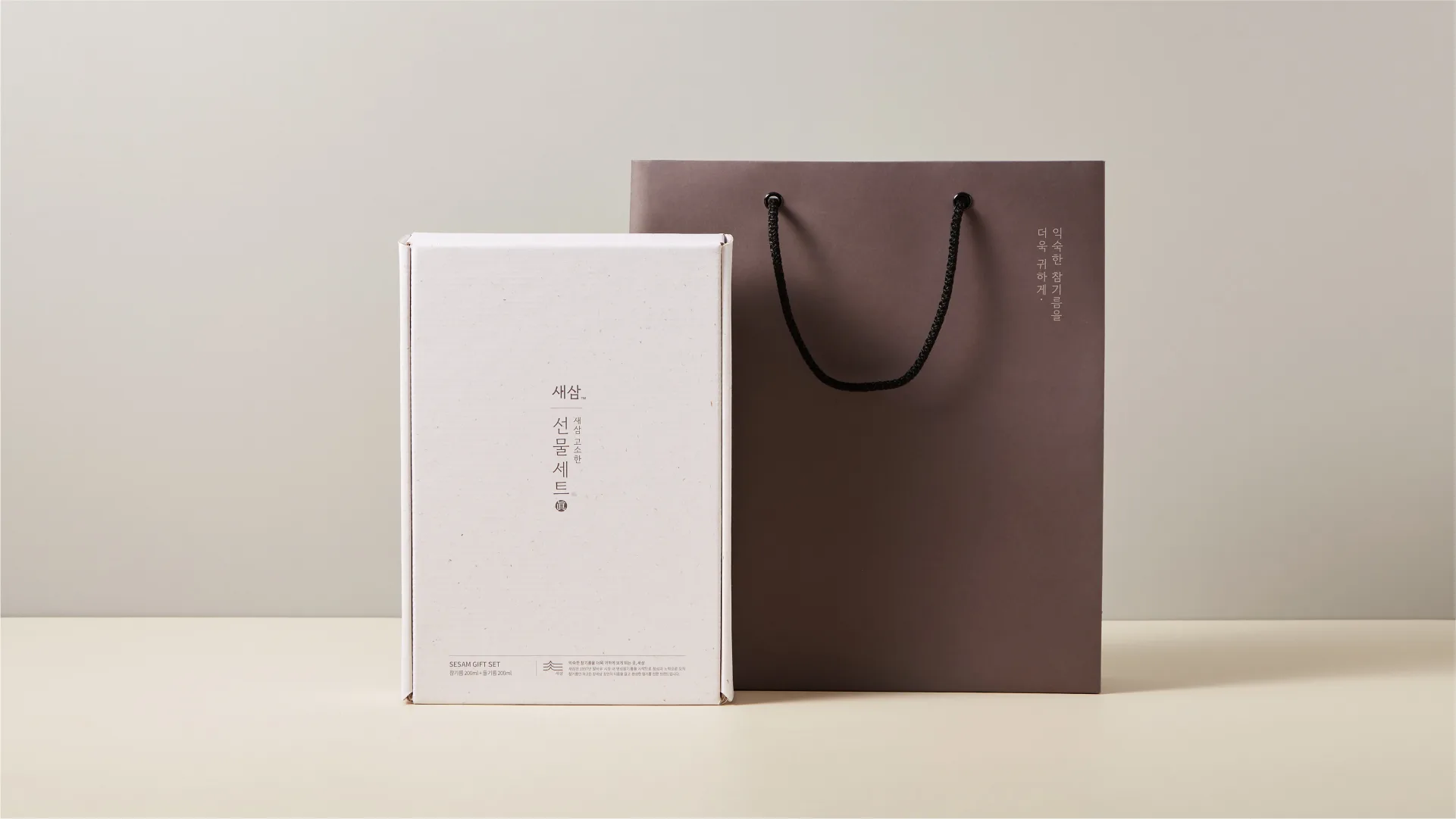 SESAM Oil House's premium gift set packaging. Embodying the brand's value of making familiar sesame oil more precious. SESAM Oil House gift box and shopping bag in a clean product shot